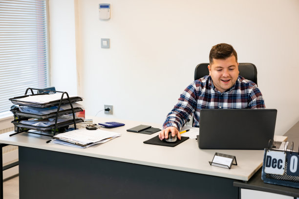 在办公室，年轻忙碌的商人在笔记本电脑上工作图片下载