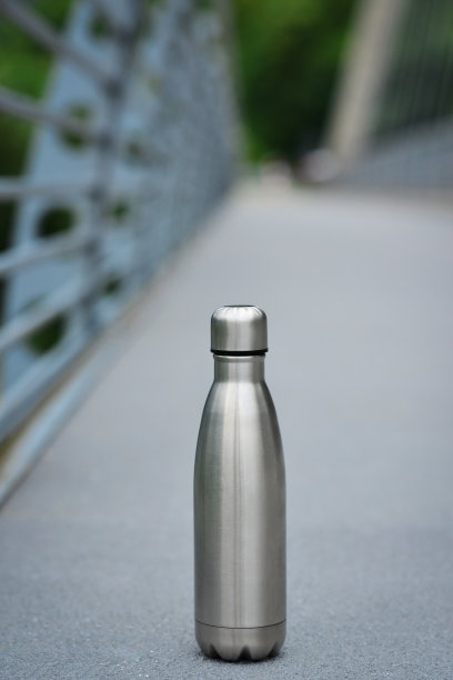 钢水瓶在背景自行车道在山中。银的颜色。副本的空间。零浪费，无塑料。图片下载