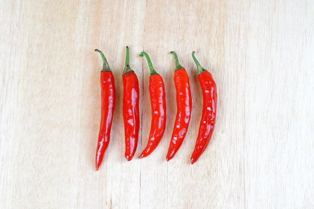 棕色木板上的红辣椒图片下载