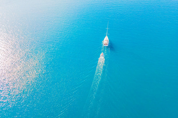 白色豪华游艇在清洁的蓝色海面上航行图片下载