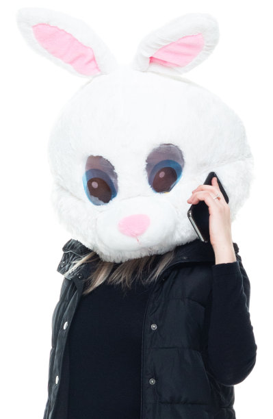 白种年轻女子无袖站在白色背景前，戴着面具-伪装和使用手机图片下载