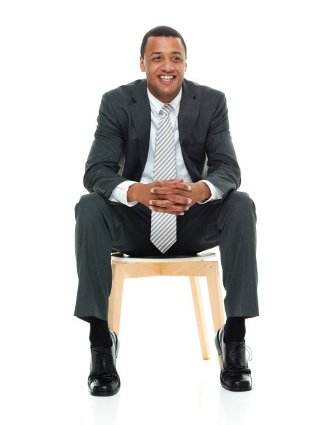 非裔美国人种族的年轻男性商务人士，穿着商务服装坐在白色背景前图片下载