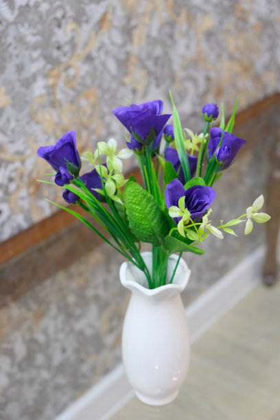 玻璃桌上，白色花瓶里的人造春花花束，家居装饰图片下载