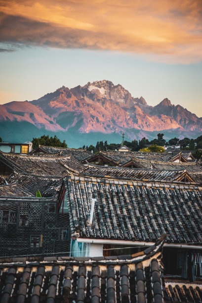 在中国丽江大雁古镇玉龙雪山的屋顶上看日出图片下载