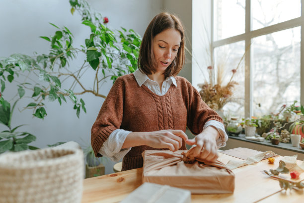 年轻女子用织物包装礼盒图片下载
