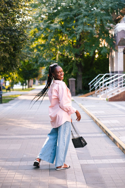 漂亮的黑人女人编着辫子在街上摆姿势。图片下载