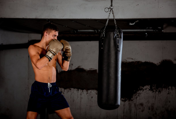 西班牙综合格斗选手用拳击袋练习踢腿图片下载