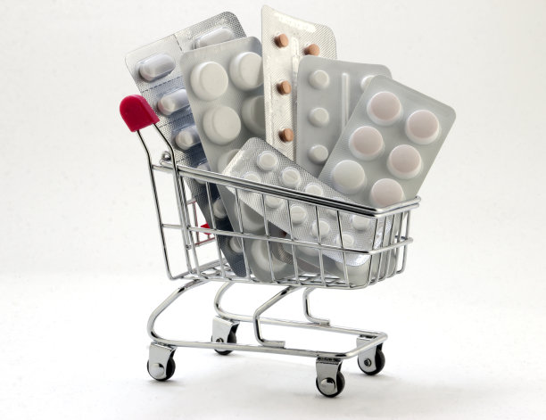 红色提手的篮子里装满药片，白色背景上隔离的药物。特写镜头。图片下载