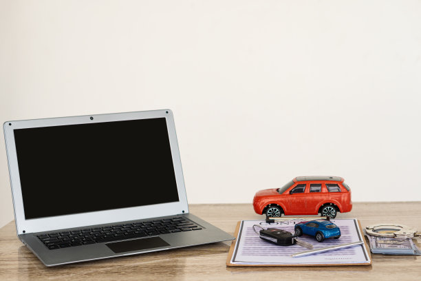 小型汽车和笔记本电脑的钥匙，桌子上的文件，汽车交易和保险的概念。图片下载