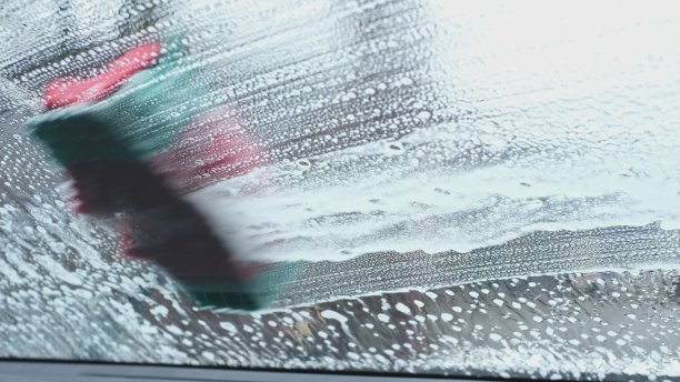 清洁和清洗汽车前挡风玻璃使用从尼龙纤维刷流出的汽车香波在玻璃上产生活性泡沫的肥皂泡沫图片下载