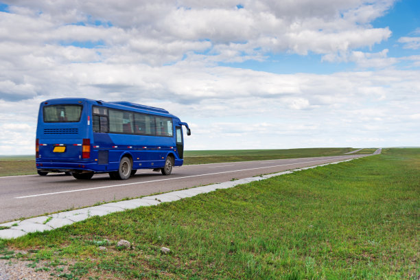 蓝色的公共汽车驶过草原图片下载