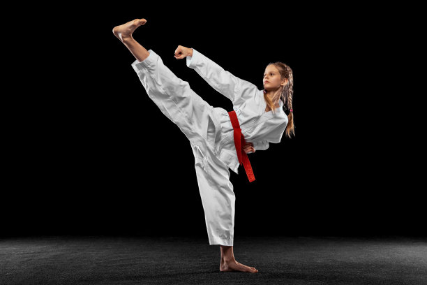 传单。年轻女孩的肖像，青少年，跆拳道运动员单独练习孤立在黑暗的背景。体育、教育、技能的概念图片下载