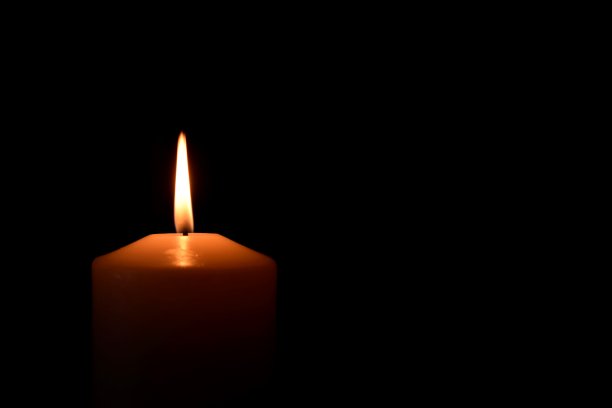 燃烧的蜡烛在黑色背景上的特写图片下载