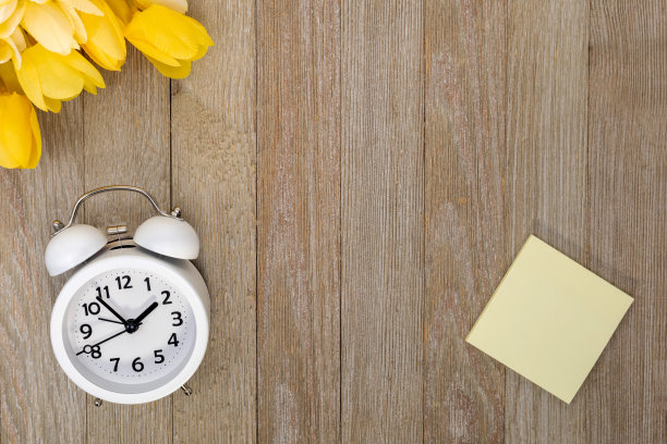 白色闹钟，木制记事本，黄色郁金香。图片下载