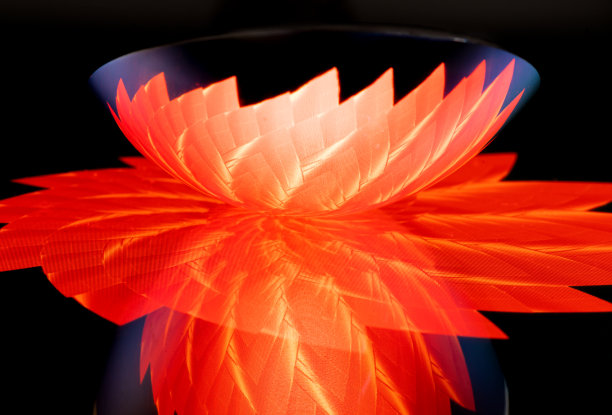 在红色黑色图案的背景上彩色反射的食匙的特写图片下载