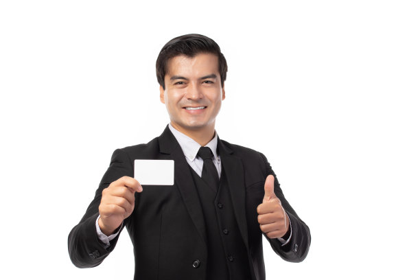 穿着黑色西装的英俊商人竖起大拇指，拿着白色背景的信用卡。商业，技术，电子商务和在线支付的概念。图片下载