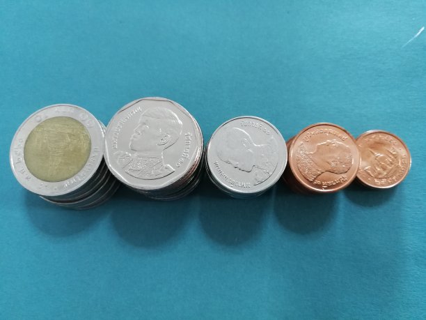 堆栈的硬币在蓝色的背景。图片下载