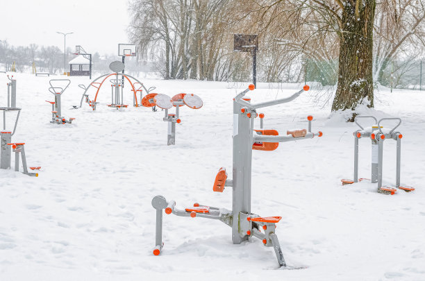 有力量训练设备的运动场。冬天的运动模拟器。公园里的雪图片下载