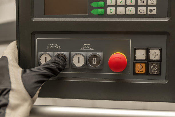 在工厂里，手动按下木工机器的电源按钮图片下载