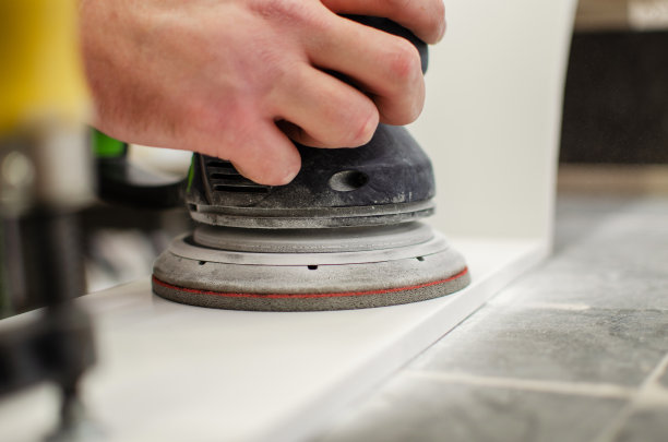 磨床。工人用手工砂光机研磨木制零件图片下载