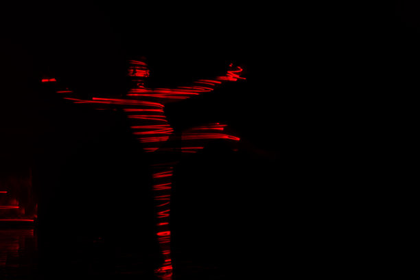 芭蕾舞演员在红灯前跳舞，用华丽的舞蹈动作表达地狱。图片下载