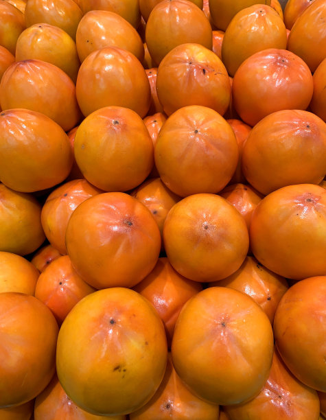 鲜橙色的柿子堆得整整齐齐图片下载