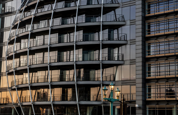 重复结构的现代建筑，反射着天空和云彩。图片下载