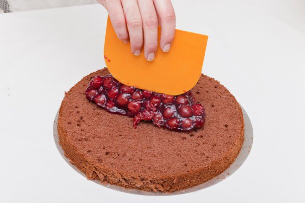 把樱桃涂在蛋糕上的糖果师图片下载