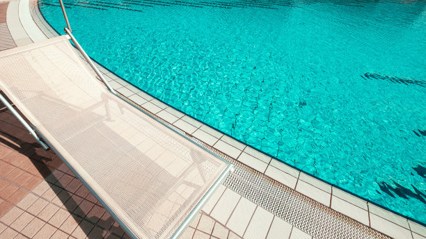 度假村游泳池。夏季度假椅，豪华酒店泳池休闲休息室。海滩懒人的马车。日光浴浴床度假。碧水蓝天，阳光快乐旅游度假。图片下载