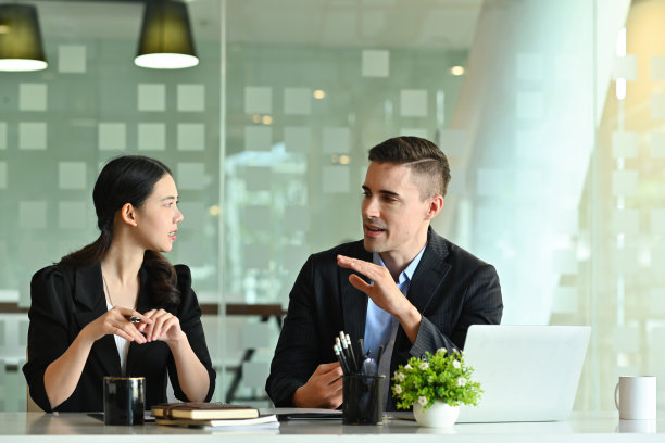 商务人士在现代办公桌旁一起工作的照片，以舒适的会议室为背景。图片下载