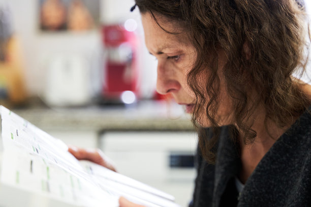 年长的女性正在阅读在家做covid-19抗原快速检测的说明图片下载