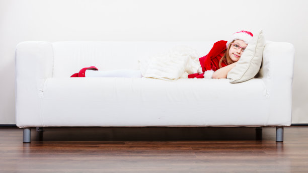 可爱的小姑娘在沙发上爬行。图片下载