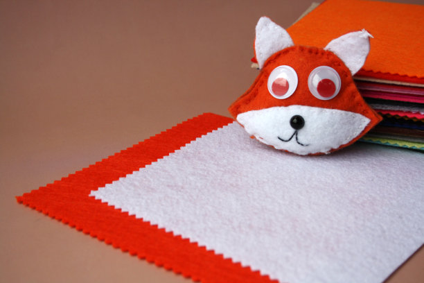 毛毡玩具用毛毡制成的儿童玩具布做的狐狸。有孩子的创造力。用你自己的双手DIY项目。图片下载