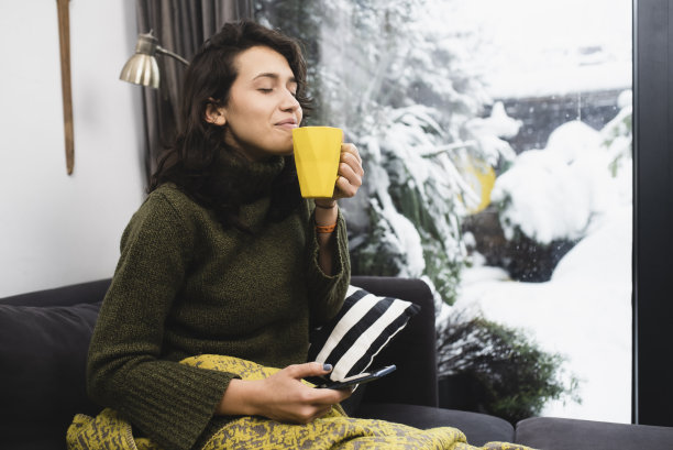 年轻女子在冬天的早晨享受着咖啡的香味图片下载