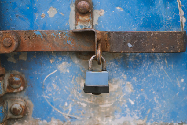一张集装箱蓝色金属门上的旧锁的照片。图片下载