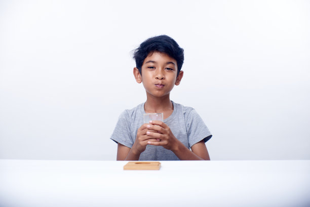 一个亚洲男孩拿着一杯健康的新鲜牛奶图片下载