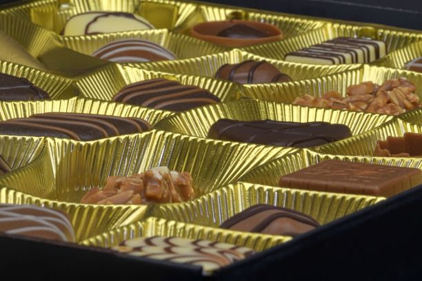 不同的巧克力果仁糖。一盒不同形状的比利时果仁糖。比利时白巧克力，黑巧克力和牛奶巧克力。特写镜头图片下载