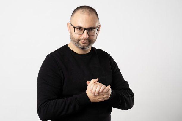 一个戴黑框眼镜的男人在白色背景上满意地摩挲着双手图片下载