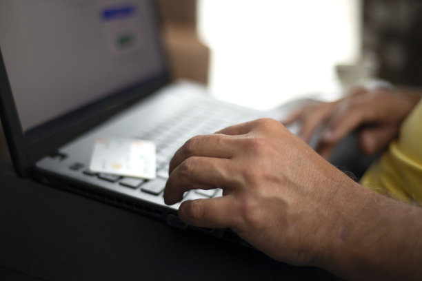 男子用信用卡使用笔记本电脑进行网上购物图片下载