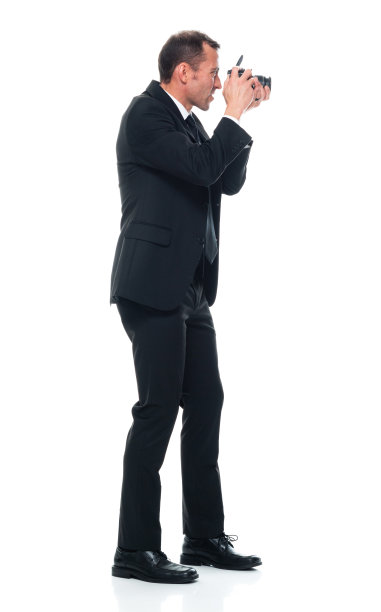 白人男性游客，穿着职业装，手持相机站在白色背景前图片下载