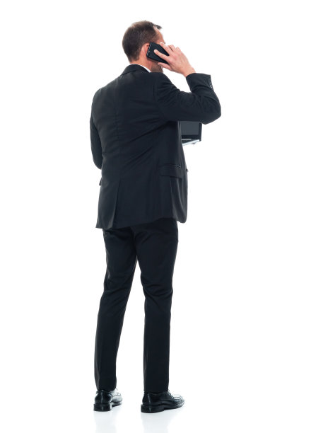 白人年轻男性，穿着职业装，站在白色背景前使用电脑图片下载