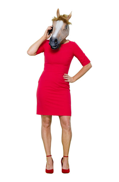 白种人年轻女性穿着马服，在白色背景前使用智能手机图片下载