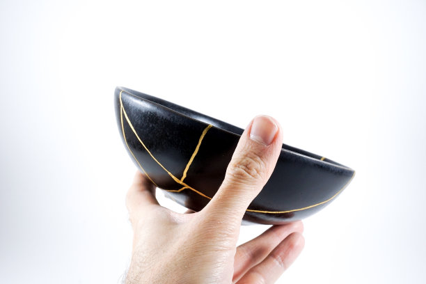 孤立的黑色日本金木碗，仿古陶器修复金裂纹。传统的定金方法。图片下载