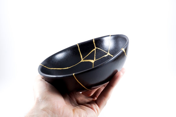 孤立的黑色日本金木碗，仿古陶器修复金裂纹。传统的定金方法。图片下载