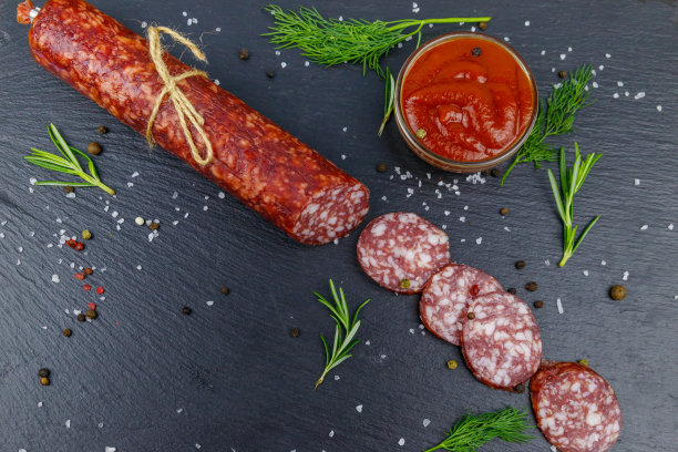 黑色石板上的意大利香肠配番茄酱和香料。俯视图图片下载