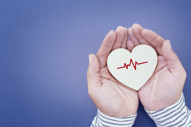 男子双手捧着白纸，心脏形状和心电图，心脏健康，世界卫生日，世界心理卫生日，医疗和幸福。图片下载