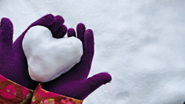手在充满活力的紫色手套握心形雪球股票照片图片下载