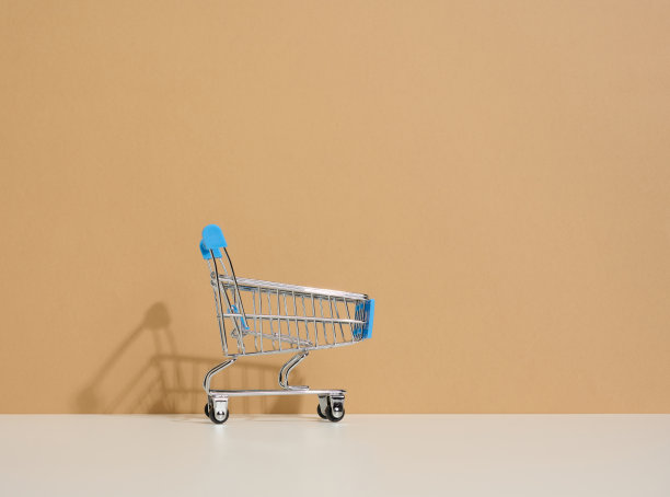 棕色背景上的空微型购物车。季节性促销，复印空间，网上购物图片下载