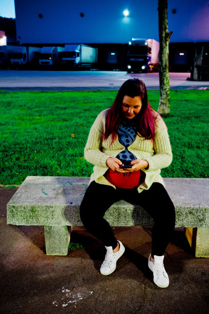 美丽的年轻白人妇女微笑的肖像坐在外面图片下载