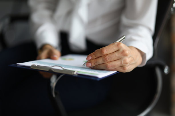 女性手握笔，在商务纸上签名图片下载